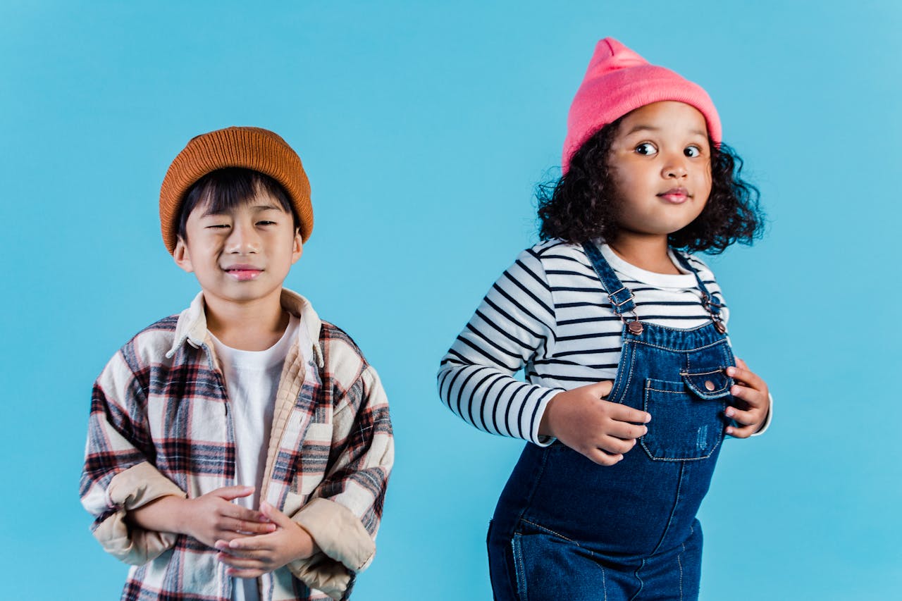 digital Multiethnic kids in casual clothes standing on blue background and making grimace in room