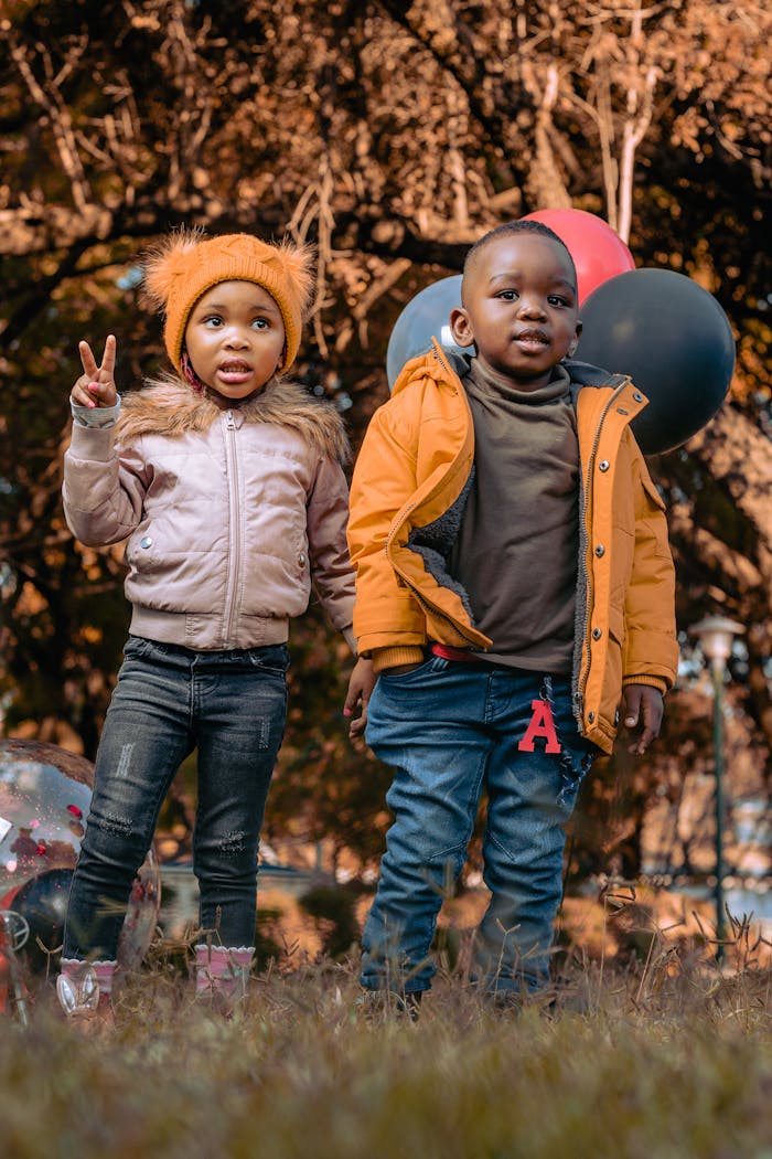 creative-02 Two children in jackets enjoying a sunny autumn day outdoors with balloons.